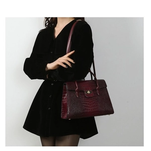 Retro burgundy tote bag with crocodile texture and gold lock shown on model