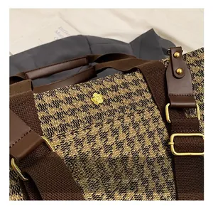 Detail shot of golden camellia hardware and vintage houndstooth fabric on women handbag