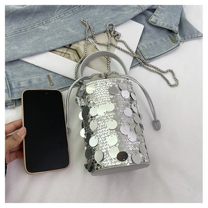 Close-up of silver sequin bucket bag with metal chain strap and drawstring closure