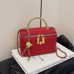 Elegant red quilted leather box bag with gold metal handle and camellia charm pendant