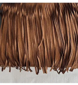 Detailed view of long dark brown fringe tassels on a vintage crossbody shoulder bag