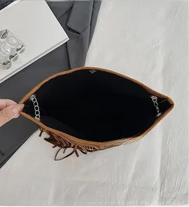 Detailed view of brown suede bag interior with magnetic closure and black fabric lining