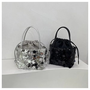 Detail of sequin bucket bag with drawstring closure and metallic chain straps in silver and black