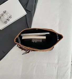 Interior view of brown fringe shoulder bag showing spacious storage for tablet and books