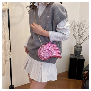 Vue détaillée du sac bandoulière rose métallisé en forme de conque avec chaîne dorée