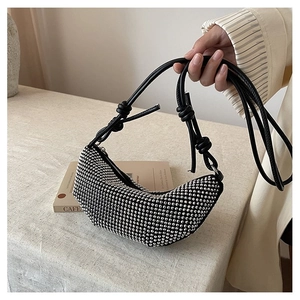 Detalle del bolso bandolera de media luna negro con diamantes de imitación y asa anudada