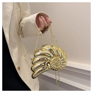 Détail d'un sac de soirée doré en forme de coquillage avec texture métallique et chaîne