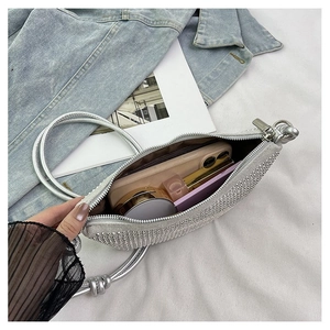 Interior del bolso de pedrería plateada con espacio para móvil y maquillaje