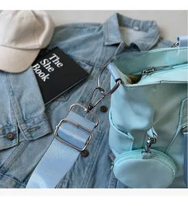Dettaglio borsa a tracolla in nylon azzurro con fibbie argentate e portamonete rotondo