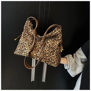 Détail du cabas en nylon léopard avec poignée en cuir nouée marron et breloques dorées