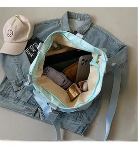Dettaglio dell'interno spazioso della borsa tote verde menta con vari scomparti organizzati