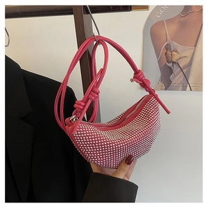 Detalle de bolso medialuna rosa con pedrería y correa anudada para fiestas vip