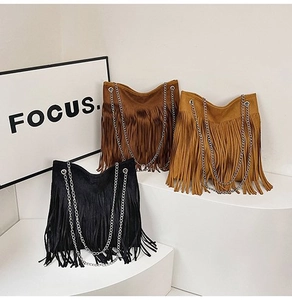 Three colors of suede tassel shoulder bags with metallic chain straps on display