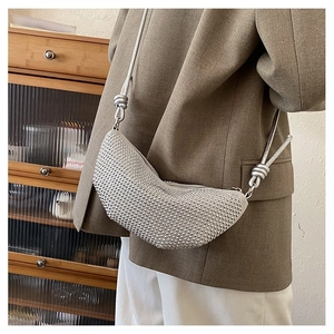 Detalle de bolso medialuna plateado con brillantes pedrería y correa de cuerda con nudos