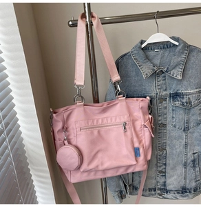 Dettaglio borsa tote in tela rosa con pochette laterale e tracolla rimovibile