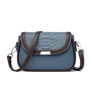 Sac bandoulière bleu à rabat texture serpent et lanières marron tendance style 2024