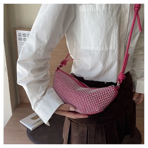 Bolso bandolera rosa con forma de media luna, pedrería y detalles de nudos