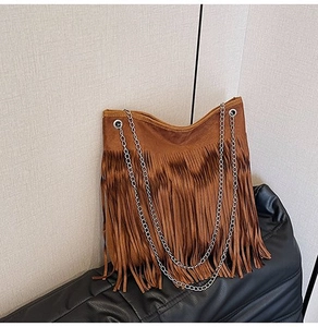 Detail of brown suede fringe shoulder bag with double silver chain straps in retro style