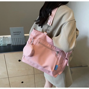 Dettaglio laterale della borsa a tracolla in nylon rosa con cinturino regolabile e borsellino