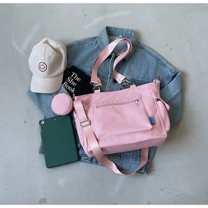 Borsa tote in nylon rosa con portamonete tondo sopra una giacca di jeans blu
