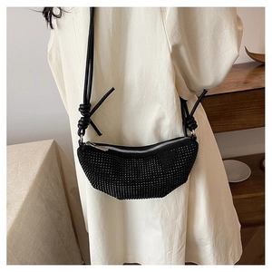 Detalle del bolso de media luna negro con pedrería brillante y correa de nudo