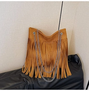 Close-up of brown suede bucket bag featuring long fringes and double silver chain straps