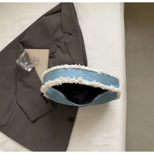Détail du sac croissant en denim avec bordure en fausse fourrure et fermeture éclair