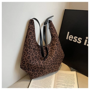 Brown leopard print dumpling crossbody bag with black leather strap in modern setting
