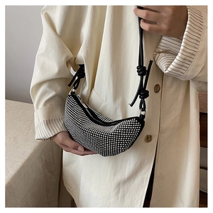 Detalle del bolso bandolera de media luna con pedrería y correa anudada en modelo