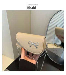 Dettaglio della mini borsa a tracolla kaki in pelle martellata con fiocco in argento