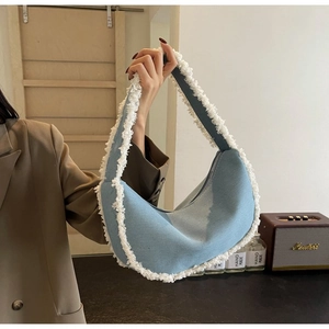 Détail du sac croissant en denim bleu clair avec bordure en fausse fourrure blanche
