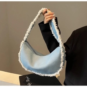 Détail du sac croissant en denim bleu clair avec bordure en fausse fourrure et fermeture