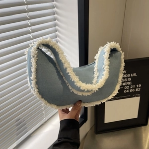 Détail du sac croissant en denim bleu clair avec bordure en fausse fourrure blanche et couture