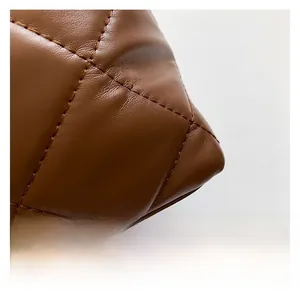 Close-up of brown quilted faux leather texture on a stylish women crossbody handbag