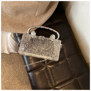 Close-up of frozen texture acrylic box bag with silver handle and metallic chain strap