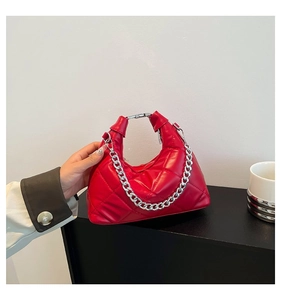 Detail of red quilted hobo bag with silver chain strap and high-gloss leather finish