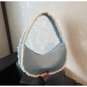 Sac hobo en denim bleu avec bordure en fausse fourrure blanche et fermeture éclair
