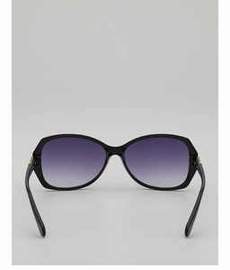 Detail of oversized black sunglasses with purple gradient lenses and gold metal hinges