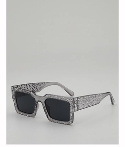 Detail of grey translucent frame sunglasses with dense rhinestone embellishments and dark lenses