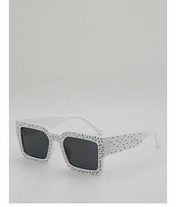 Macro shot of white rectangle sunglasses with sparkling silver rhinestones on the frame