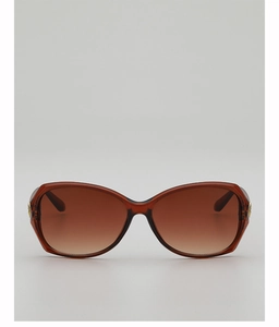 Detailed view of brown gradient lenses and golden metal accents on large frame sunglasses