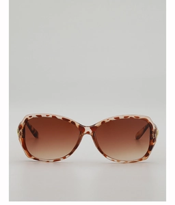 Detail of tortoise shell sunglasses frame with golden metal hinges and gradient lenses