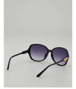 Detail von schwarzer ovaler Sonnenbrille mit lila Verlaufsgläsern und goldenem Scharnier