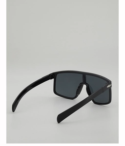 Détail de la monture noire avec charnière triangle en métal argenté et verres gris foncés