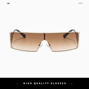 Macro detail of gold metal frame and gradient brown lens on wrap-around sunglasses