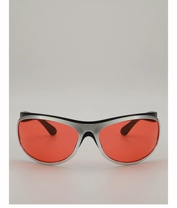 Close-up of futuristic silver curved sunglasses with vibrant red lenses and sporty design
