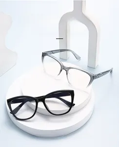 Close-up of geometric eyewear frames in black and grey on a white display stand
