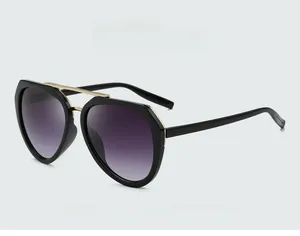 Détail de lunettes de soleil polygonales avec verres dégradés violets et pont doré