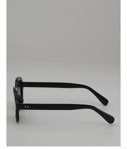 Close-up of wide black sunglasses frame featuring decorative silver metal rivets