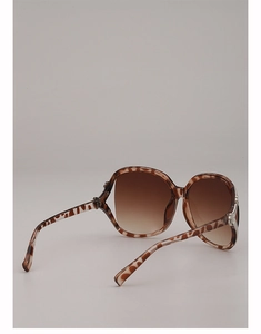 Detail of tortoise shell sunglasses with silver metal accents and brown gradient lenses